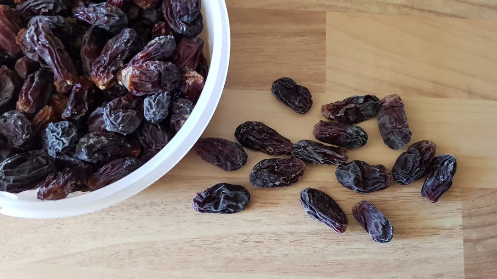 My dehydrated red grapes, some in a bowl, some scattered on the counter