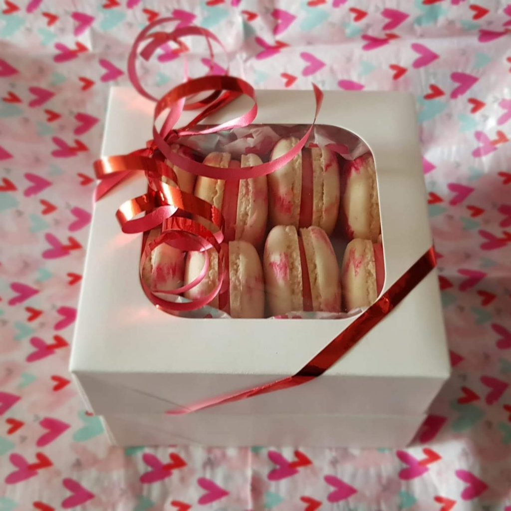 Mini Macarons in a gift box with a ribbon and bow, ready to be enjoyed.