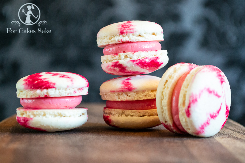 Four raspberry ripple macarons.